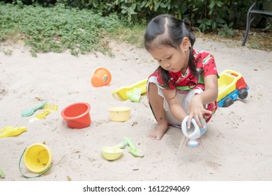 Asian Baby Girl Playing Sand Outdoor. Kid Building Sand Castle. 