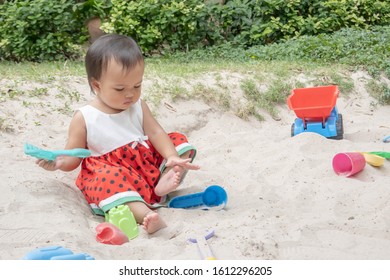 Asian Baby Girl Playing Sand Outdoor. Kid Building Sand Castle. 