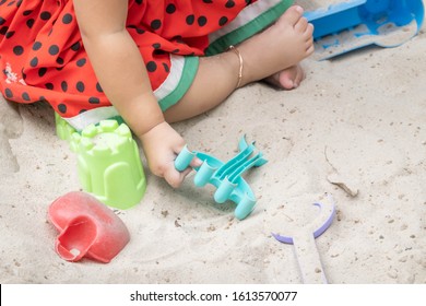 Asian Baby Girl Playing Sand Outdoor. Kid Building Sand Castle. 