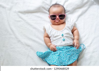 Asian Baby Girl Wearing Swiming Suit And Pink Sunglasses On White Background, Baby In Beach Wear Fashion