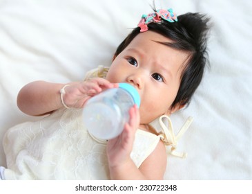 Asian baby infant eating milk from bottle