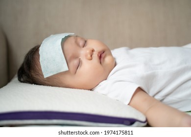 Asian Baby Infant Get Fever And Apply Cool Patch On Forehead Sleeping At Home After Vaccination. Cold Pad Gel Healing Temperature. Baby Sick After Back From Hospital.