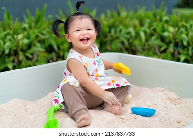 Asian Baby Laugh And Play Sand In Sandbox At Outdoor. 1 Year 6 Month Baby Enjoy To Play Sand Use As Concept Of Play, Health, Mood And Motion Of Baby And Kid Development.