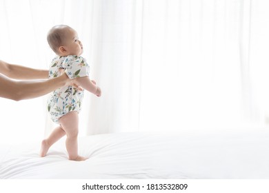 Asian Baby Learning To Walk For The First Step On The Soft Bed