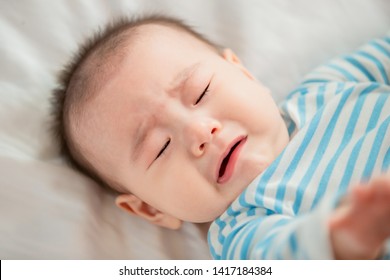 Asian Baby Lying On The Bed And Crying