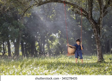 Asian baby  on swing with puppy.
