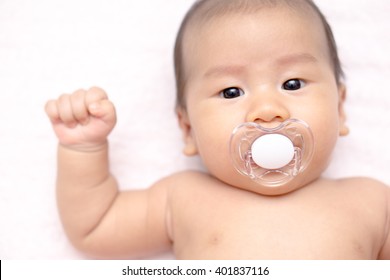 An Asian Baby With Pacifier