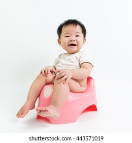 Asian Baby Sitting On Potty Over White Background