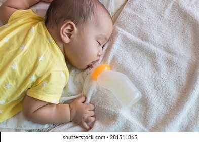 Asian Baby Sleeping And Drinking Milk