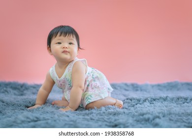 Asian Baby Smiling And Sitting On Carpet With Pink Color Background. Cute 6 Months Baby Sitting With Copy Space Use As Concept Of Valentine, Love, Learn, Education, Baby Or Kid Department In Hospital.