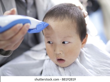 asian baby son being haircutting