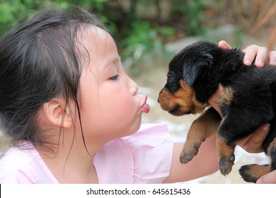 Asian Baby Want To Kiss A Baby Dog , Rottweiler Puppy And Asian Girl