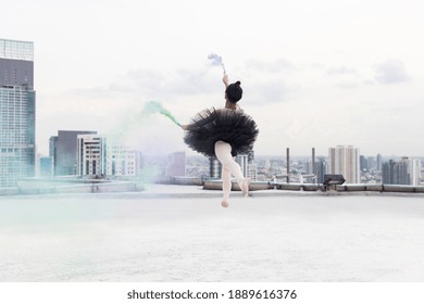 Asian ballerina ballet girl dancing with colour smoke on rooftop and cityscape view background. Female ballet dancer practicing dancing. Young ballerina ballet girl dancing - Powered by Shutterstock