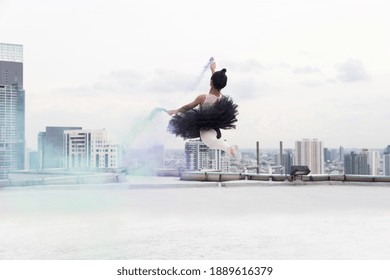 Asian ballerina ballet girl dancing with colour smoke on rooftop and cityscape view background. Female ballet dancer practicing dancing. Young ballerina ballet girl dancing - Powered by Shutterstock