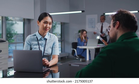 Asian Bank Manager Talking About Loan Terms To Male Client In Modern Bank Office. Young Entrepreneur Consult Financial Specialist