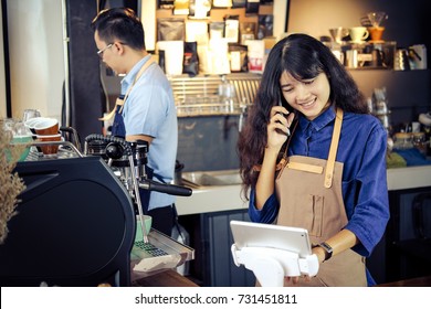 Asian Barista Talking Order By Phone In Her Shop. Cafe Restaurant Service, Small Business Owner, Food And Drink Industry Concept.