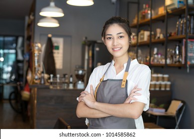 Asian barista woman standing with attractive smiling at front of cafe. Woman success to make sme business.