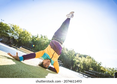 Asian B-boy Performs Breakdance Trick - Stylish Cool Teen Male Dancing At Skate Park