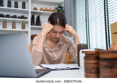 Asian beautiful business woman feel frustrated after check sale order. Young attractive female working and checking e-commerce shipping for online retail to sell vase goods at home warehouse store.