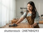 Asian beautiful cleaning service woman worker cleaning kitchen at home. Beautiful girl housewife housekeeper cleaner feel happy and wiping messy dirty dining table for housekeeping housework or chores