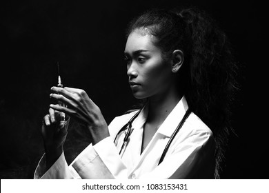 Asian Beautiful Doctor Nurse Woman In Uniform With Stethoscope And Shake Syringe, Portrait Half Body Make Up, Studio Lighting Dark Smoke Backgrounds Copy Space, Black White Monotone Color