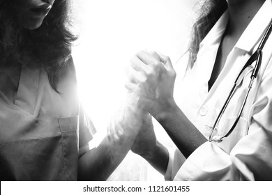 Asian Beautiful Doctor Nurse Woman In Medical Uniform With Stethoscope Hold Hands Warm Take Care Of Patient Health, Portrait, Studio Lighting Dark Smoke Backgrounds Copy Space, Black White Monotone