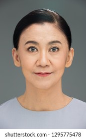 Asian Beautiful Elderly Aging Society 50s 60s Years Old Woman Wear Gray Casual Clothes Short Black Hair With Make Up, Studio Lighting Grey Background Copy Space With Smile Face Eyes Head Shot