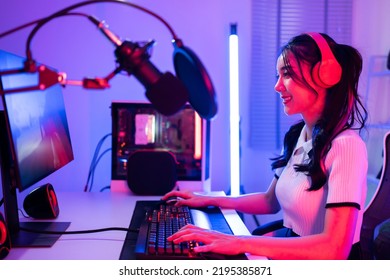 Asian beautiful Esport woman gamer play online video game on computer. Attractive young girl gaming player feel happy and enjoy technology broadcast live streaming while plays cyber tournament at home