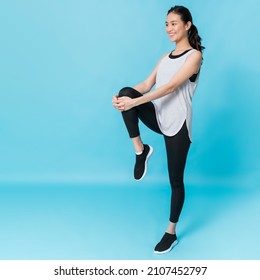 Asian beautiful happy woman stand up and stretching before exercise isolated on blue colour background.Concept of slim and healthy girl workout. - Shutterstock ID 2107452797