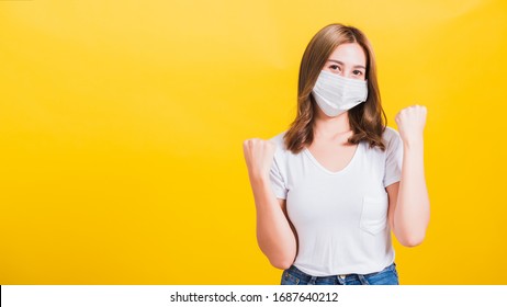 Asiatische schöne junge Frau mit Gesichtsmaske-Filter Staub pm2.5, COVID-Virus und Luftverschmutzung ihre Hände freute sich aufgeregt, nachdem sie sich von der Krankheit auf gelbem Hintergrund erholt