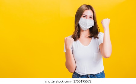 Asian Beautiful Happy Young Woman Wearing Face Mask Protection Filter Dust Pm2.5, COVID Virus And Air Pollution Her Raise Hands Glad Excited Cheerful After Recovering From Illness On Yellow Background