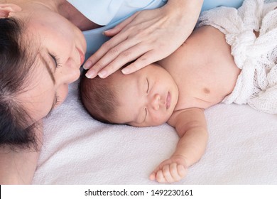 Asian Beautiful Mother Hug Newborn Baby Sleep In Bed, Adorable New Born Happy Sleep In Her Mother Arm Feeling Safe And Protect, 0-1 Month Newborn Baby And Lovely Mother Lie Down Sleep Together At Home