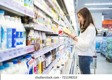 Asian beautiful woman buy some milk in a supermarket, sale, shopping, consumerism and people concept 