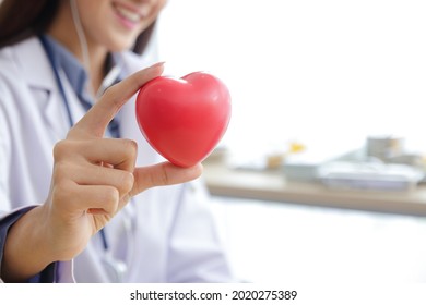 Asian beautiful woman doctor Hold the red heart ball. concept of medical services in hospitals, patient care. Copy space