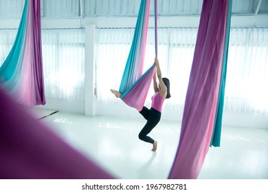 Asian beautiful woman doing aerial dance practice in hammock at studio, Asian women perform dances using a hammock in the dance - Powered by Shutterstock