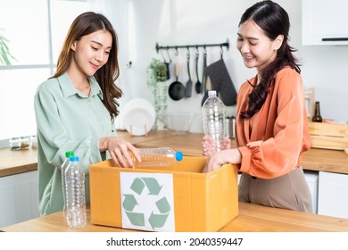 Asian Beautiful Woman Friend Separate Trash For Recycling At Home Together. Attractive Lesbian Couple Put Plastic Bottles Into Recycle Box For Ecologically Friendly And Saving Environment Zero Waste.