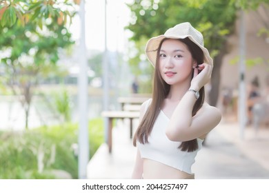 Asian Beautiful Woman With Good Skin Standing In A Cream Colored Hat Smiling Happily On Blurred Background.