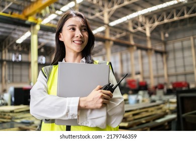 Asian beautiful woman industrial worker working in manufacturing plant. Attractive female industry factory engineer wear helmet and processes orders and product at manufactory warehouse with happiness - Shutterstock ID 2179746359