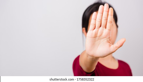 Asian Beautiful Woman Itching Her Outstretched Hand Showing Stop Gesture Front Face, Focus On Hand On White Background With Copy Space