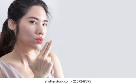 Asian Beautiful Woman Are Make Handgun Gesture And Blow On With Puckering. 