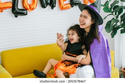 Asian Beautiful Woman Or Mother And Little Caucasian Sweet Girl Wearing, Dressing Up Halloween Costume, Playing Together With Fun, Smiling, Laughing With Happiness, Celebrating Party At Home