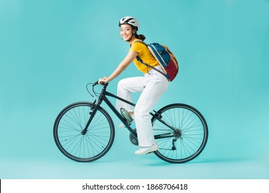 Asian beautiful woman, she is riding a city bike to work.She is looking - Powered by Shutterstock