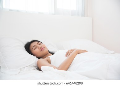 Asian Beautiful Woman Sleeping On Her Bed. Happiness Girl Smiling On Morning.