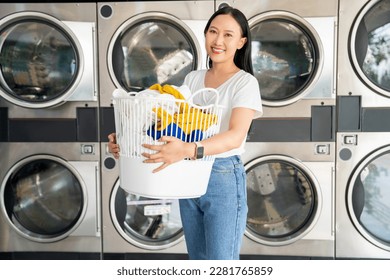 Asian beautiful woman smiling happy doing chores at the laundry - Powered by Shutterstock