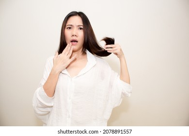 Asian Beautiful woman using hand touch on lip and hold her hair with worried and shocked about hair split and dry problem
