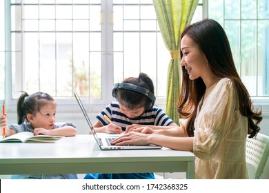 Asian Beautiful Woman Using Laptop Tele Conference Meeting With Her Colleague From Home During Coronavirus Outbreak. Working From Home, Wfh, Staycation Or New Normal Concepts