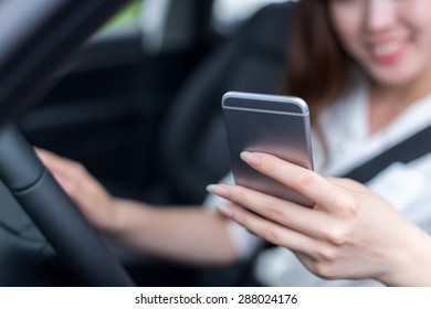 Asian Beautiful Woman Using Mobile Phone And Driving Car