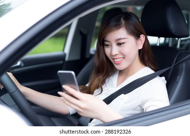 Asian Beautiful Woman Using Mobile Phone And Driving Car