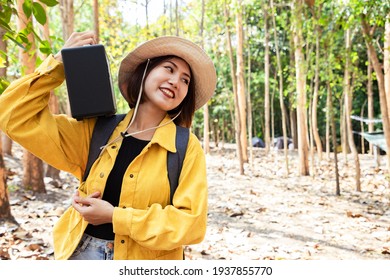 Asian Beautiful Woman Wear Brown Hat And Using Speaker In Public Park With A Happy Face Standing And Smiling. Concept Of Nature And Freedom Leisure.