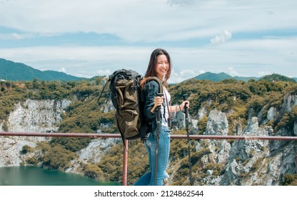 Asian beautiful woman wearing hat and casual clothes, smiling with happiness, adventure traveling alone and hiking on the top of mountains with backpack in summer vacation trip on weekend - Shutterstock ID 2124862544
